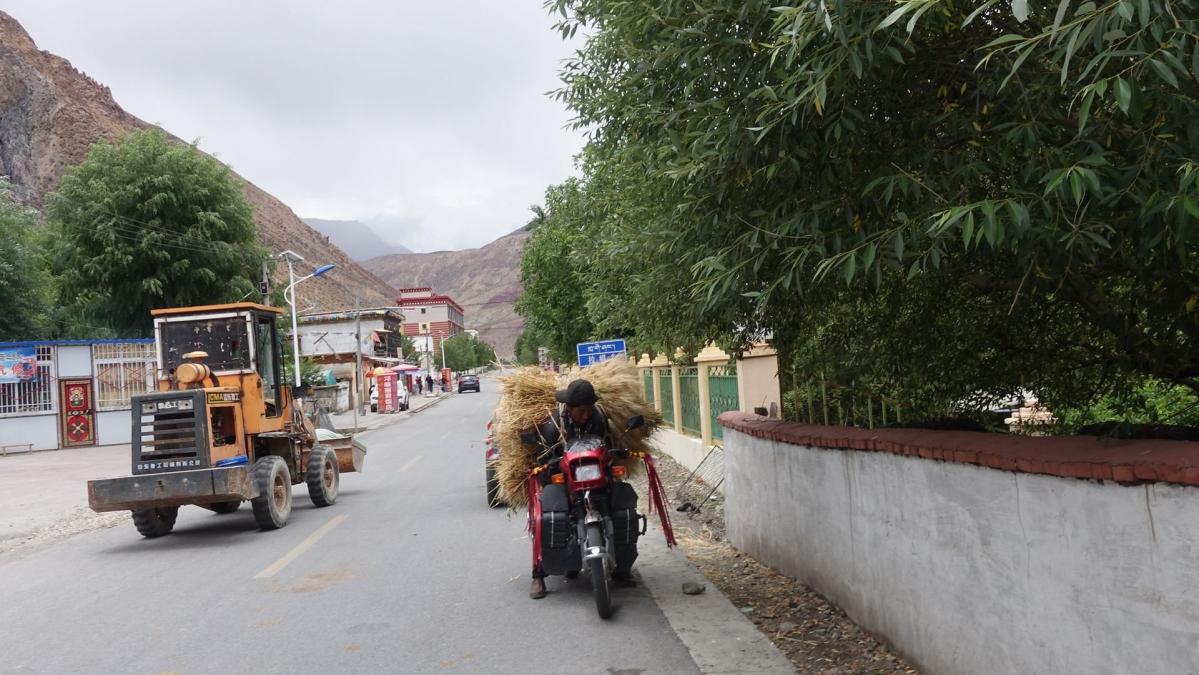 用摩托车拖青稞的藏民